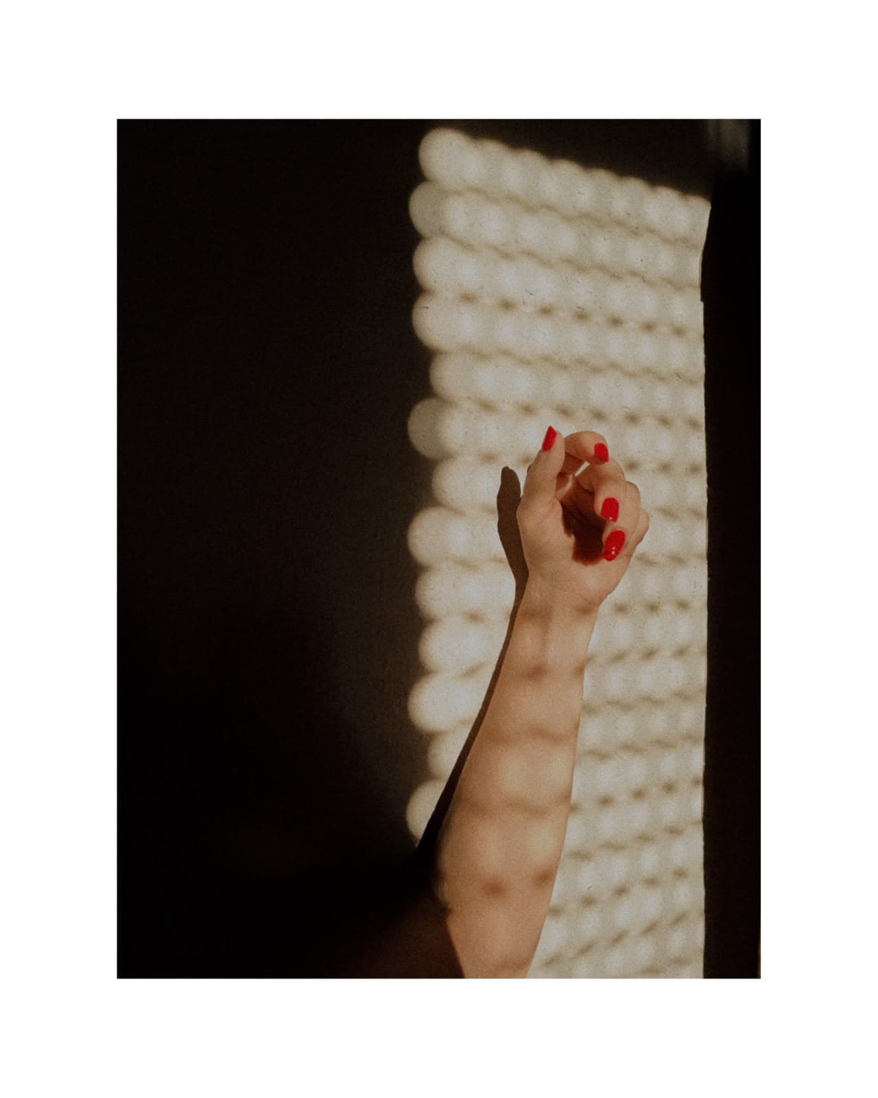 Fine Art portrait detail of hand with red nails and patterned light by Andrea Polmüller